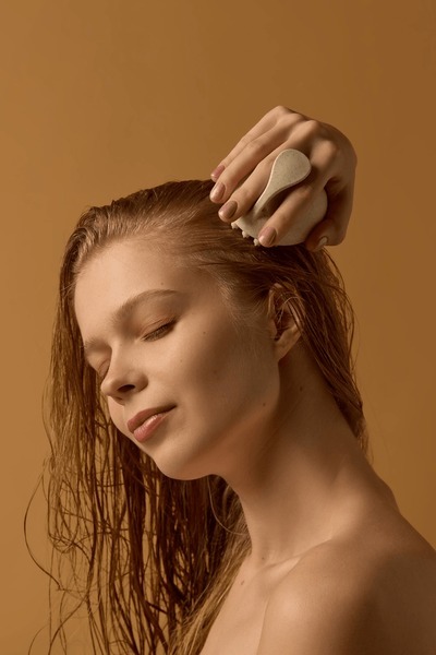 Close-Up Of A Patient Learning How To Use A Massage Tool, Illustrating Practical Advice Shared During A Personalized Hair Loss Plan New York Consultation To Improve Hydration And Nutrient Delivery To The Hair Roots.